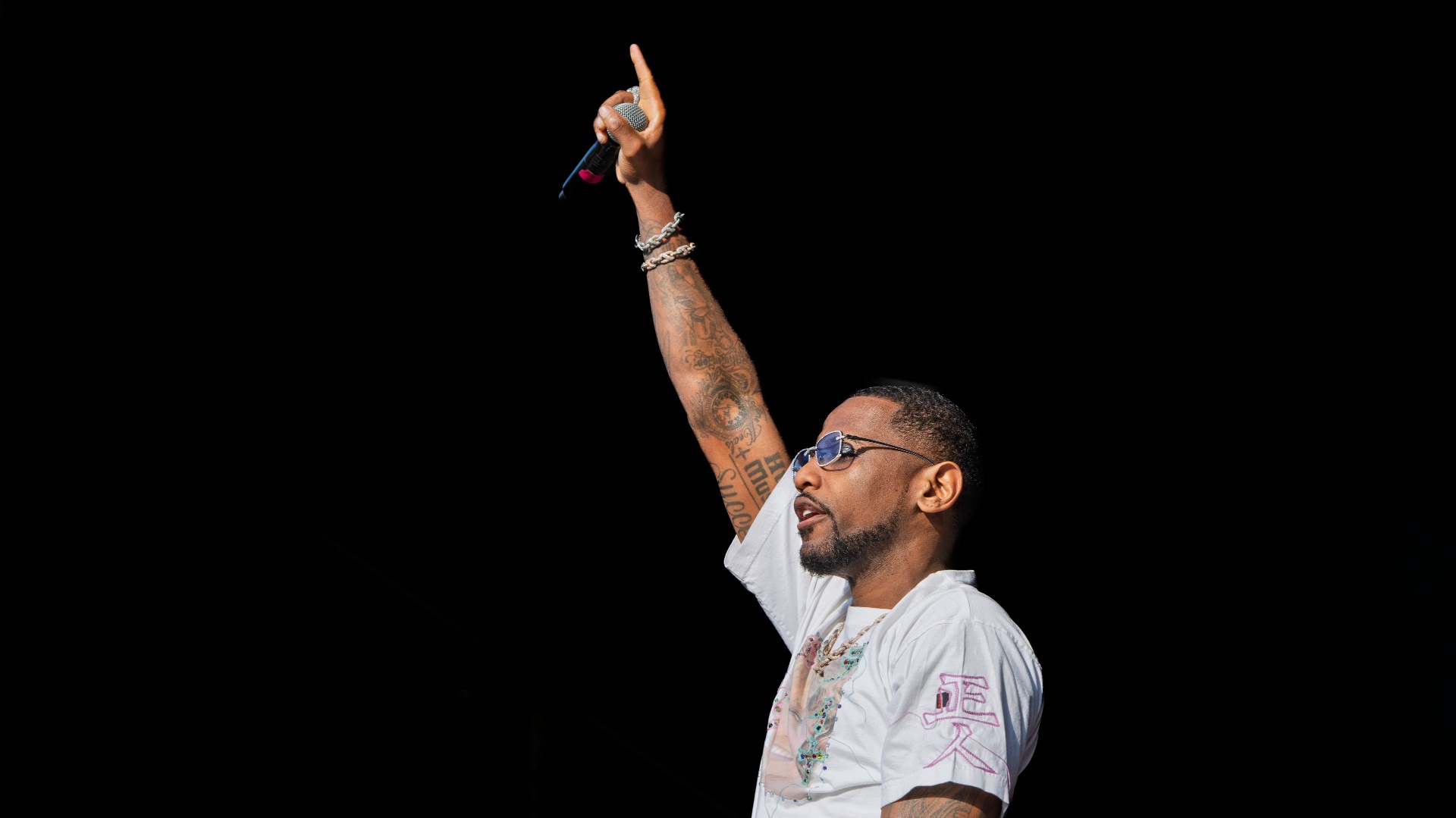 Rapper performing on stage with mic raised